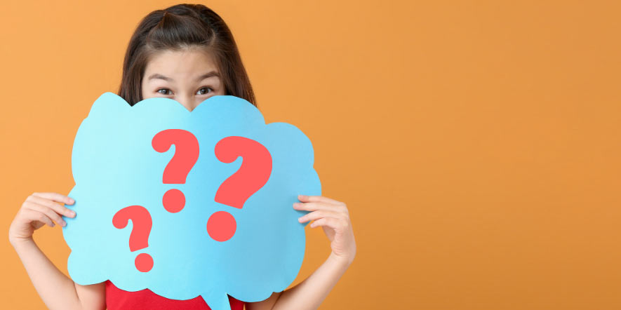 young school girl holds up a blue speech bubble with question marks on