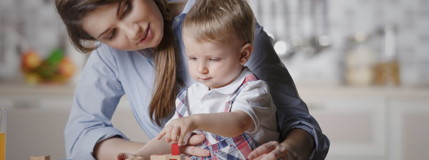 Toddler with his mother playing with blocks