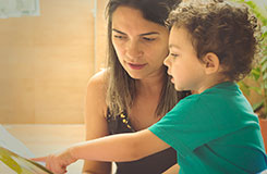 Woman helping boy to read