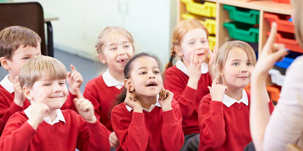 Classroom of children learning sign language