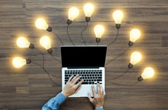 Laptop surrounded by lightbulbs