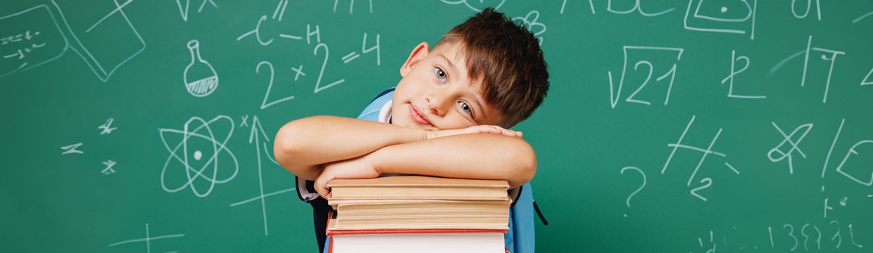 Young boy resting on some books