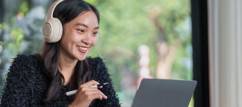 Woman on laptop with headphones