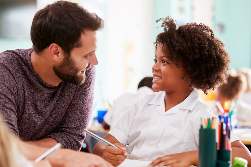 Male teacher with a child smiling